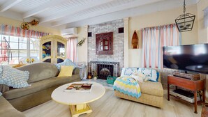 Una sala de estar acogedora con chimenea, asientos cómodos y un televisor.