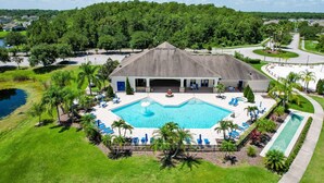 A hotel with a swimming pool, a tennis court, and a parking area. - Water View Retreat With Lanai, Heated Pool, Pool Spa, Game Room, & AC (Kissimmee)