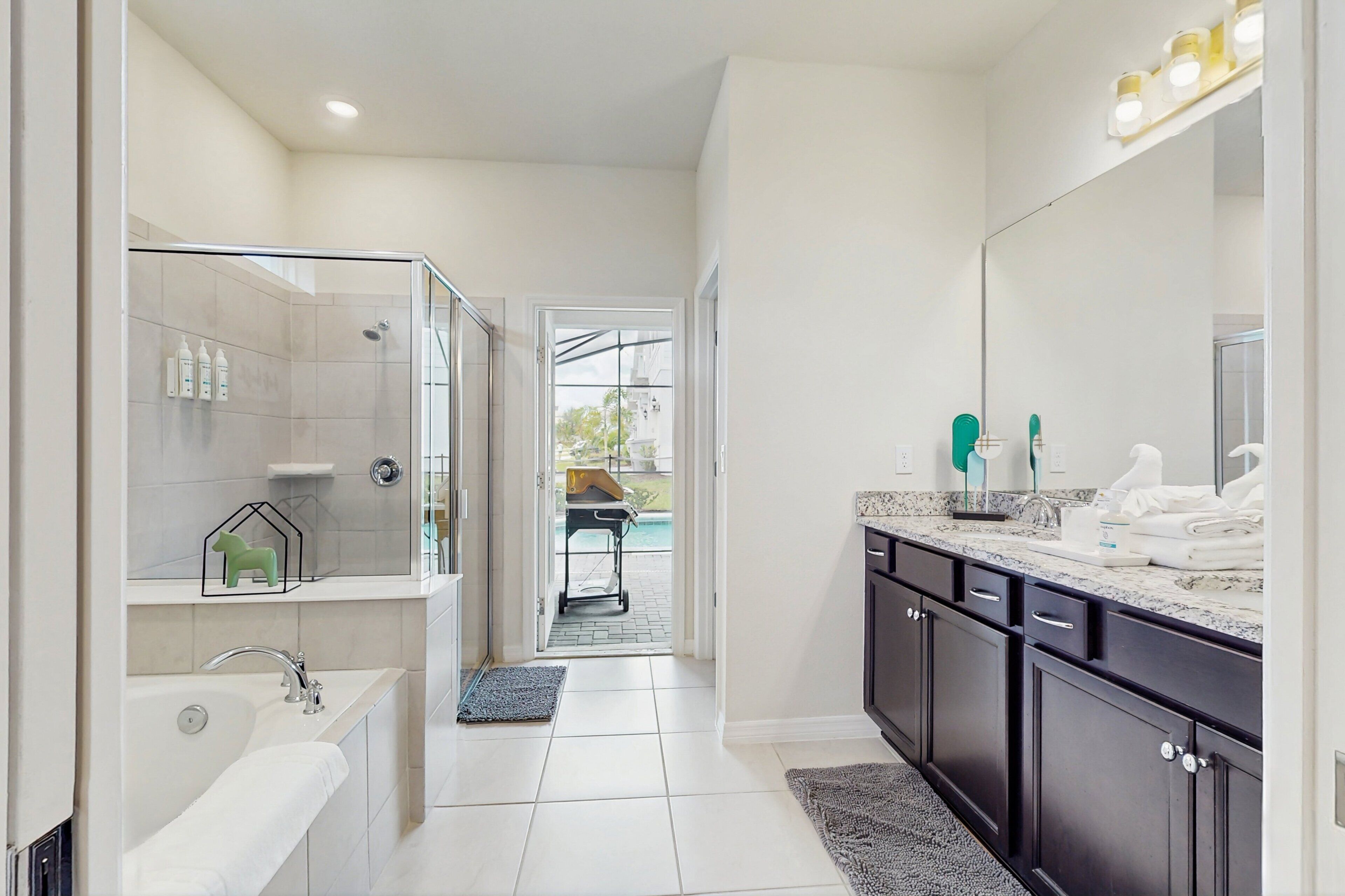 Une salle de bain moderne équipée d’une douche, d’une baignoire, d’un meuble-lavabo et d’un grand miroir.