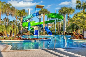A pool with a water slide, palm trees, and a clear sky. - Dog-friendly House With Private Heated Pool, Sports Courts, Game Room, Pool, AC (Davenport)