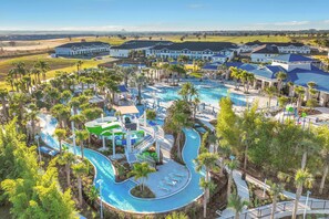 Resort com uma grande piscina, toboáguas e vários edifícios de estilo arquitetônico uniforme.