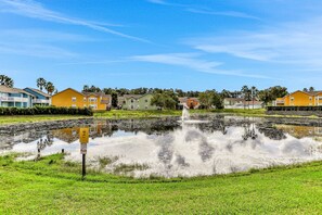 A residential area with houses, a pond, and a fountain. - Breezy Townhouse With a Pool, hot Tub, Patio, Central AC, and Washer/dryer (Kissimmee)