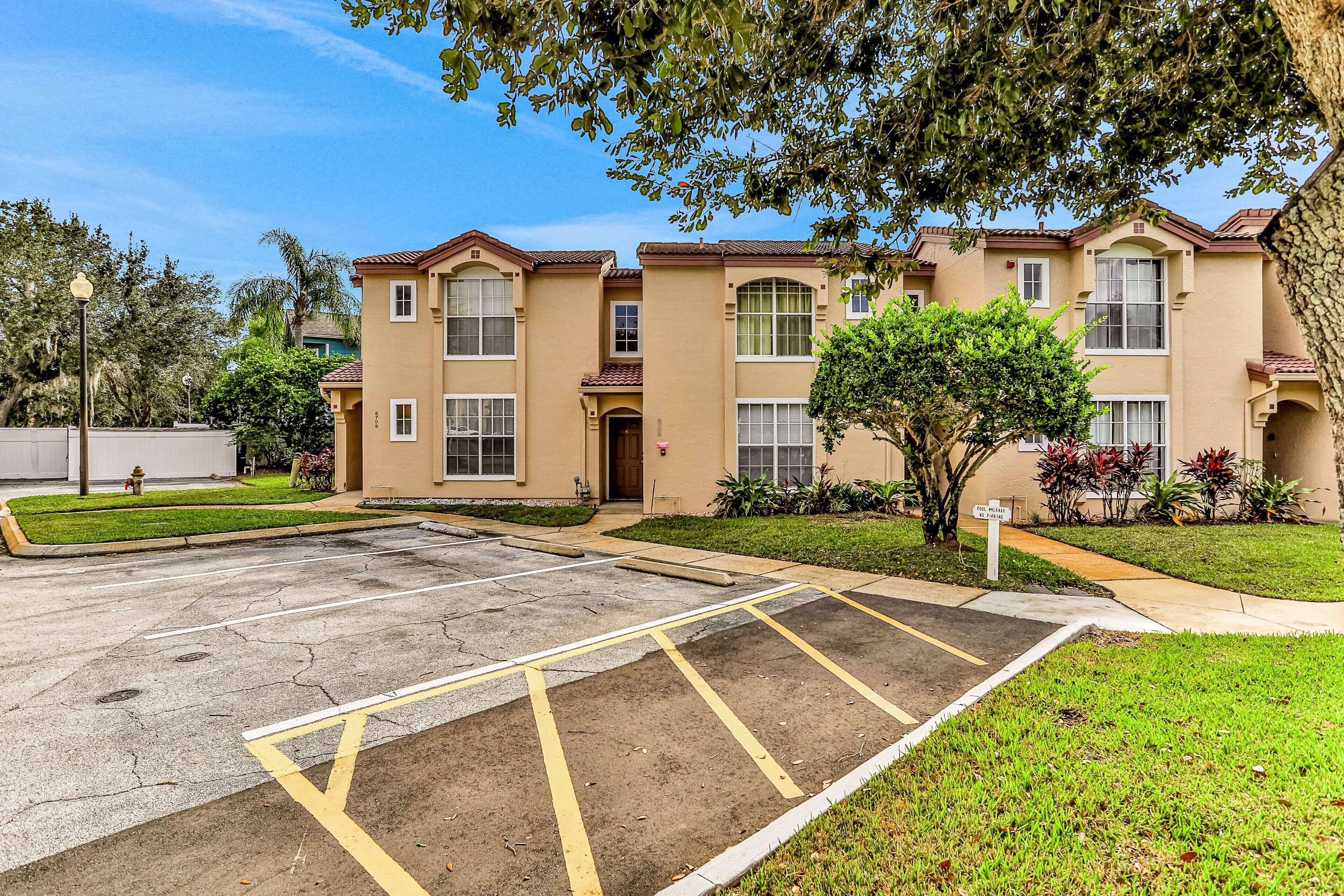 A multi-story residential building with a parking lot in front.