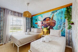 A hotel room with two beds, a large mural, a hanging light fixture, and a view of the outdoors. - Beautiful Home With Private Pool, Game Room and Basketball Court (Kissimmee)