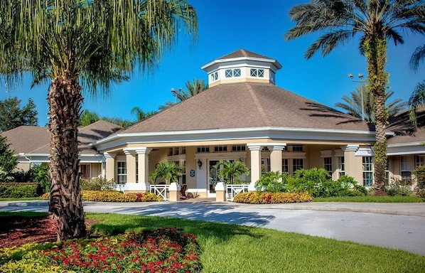 A hotel with a central entrance, palm trees, and a well-maintained garden. - Resort Condo Near Disney With Pool, hot Tub, Tennis, Central AC, & Washer/dryer (Kissimmee)