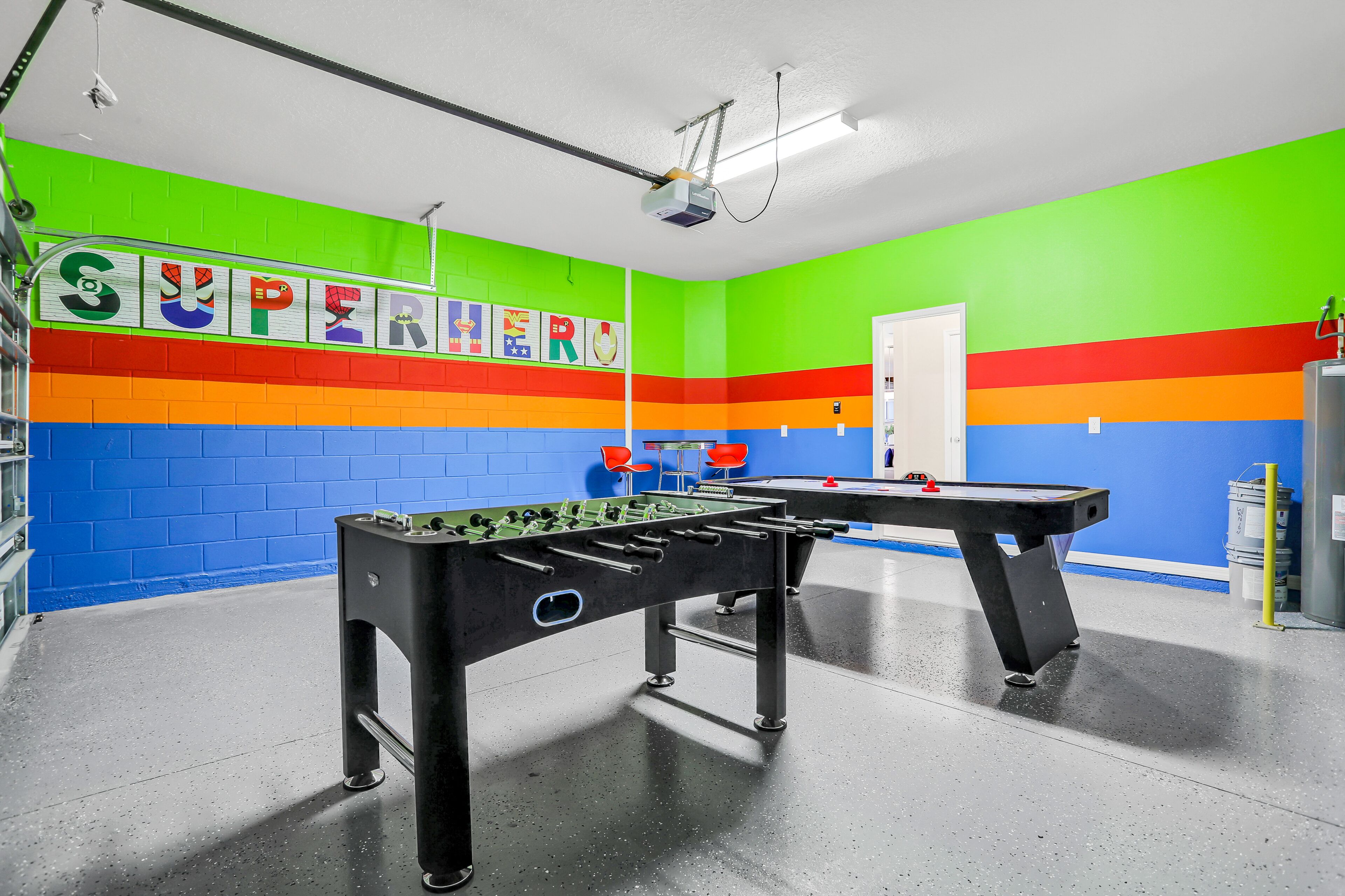 A brightly colored room with a foosball table and a projector mounted on the ceiling.