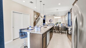A modern kitchen with a central island, stainless steel appliances, and pendant lighting. - Spacious Resort Home With Private Pool, Game Room, & Abundant Amenities (Davenport)