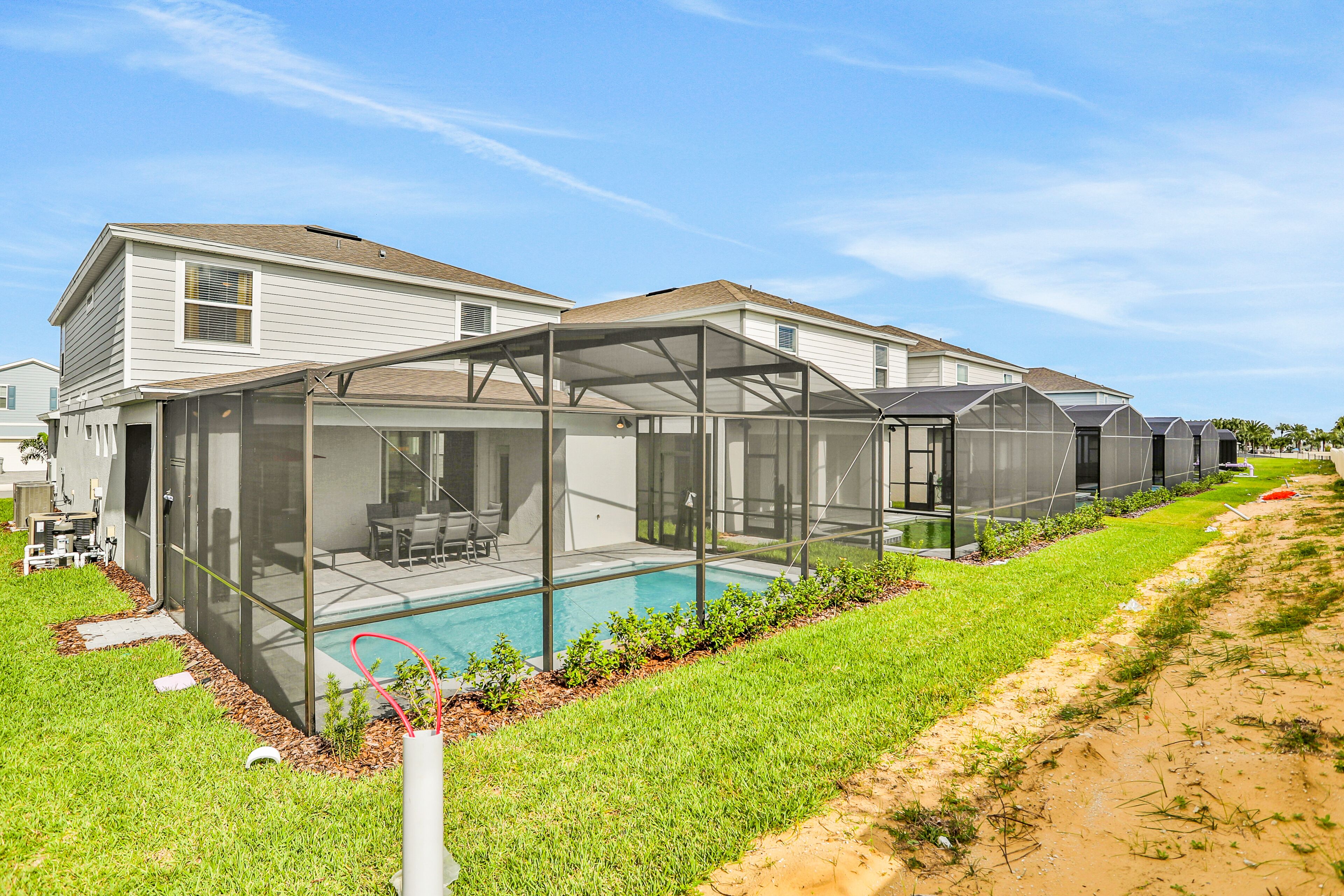A modern house with a covered outdoor area and a swimming pool.