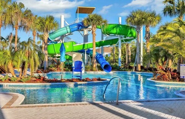 A water park with multiple slides and a pool area surrounded by palm trees. - Spacious Resort Home With Private Pool, Game Room, & Abundant Amenities (Davenport)