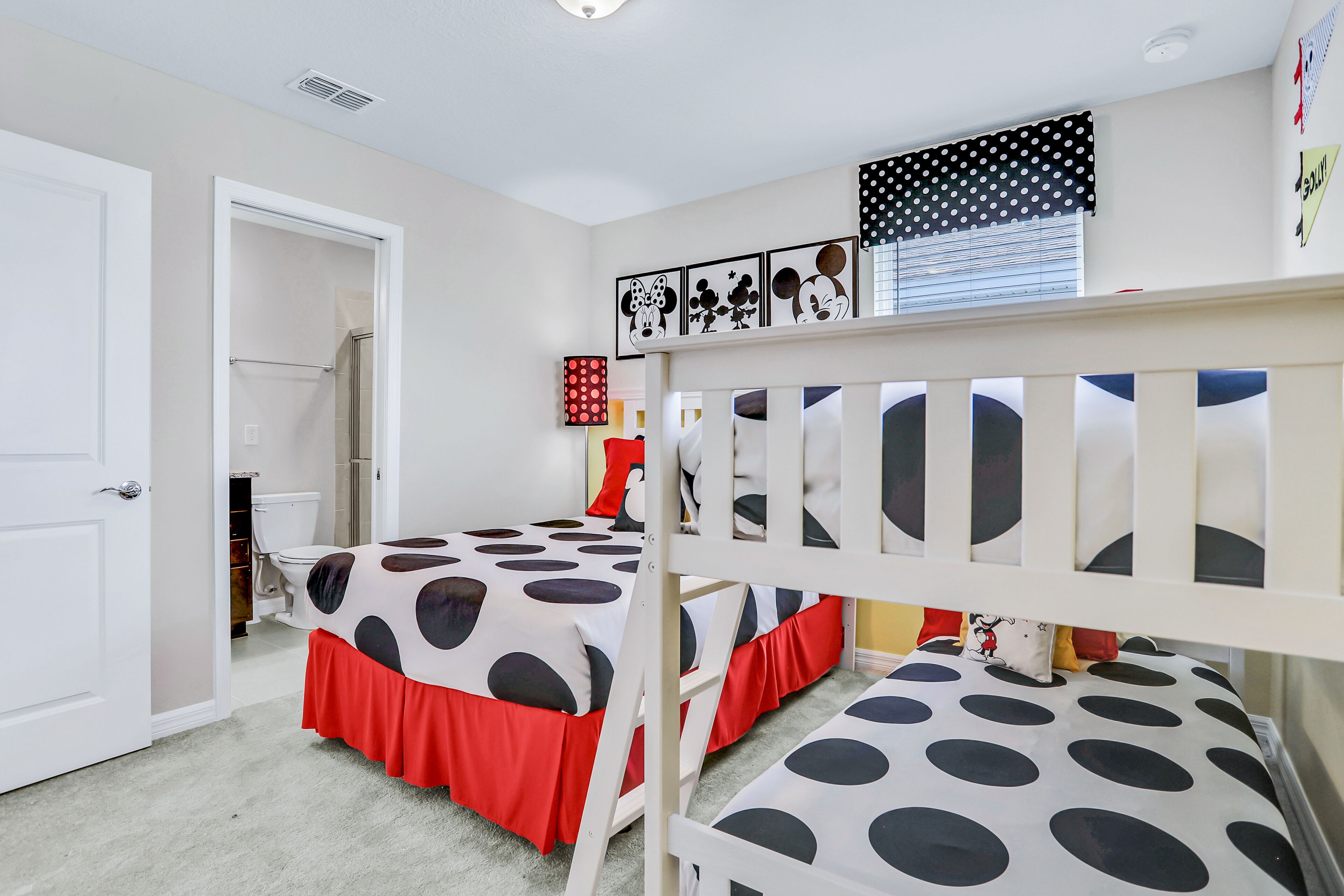 A bedroom with bunk beds, a toilet, and a shower.