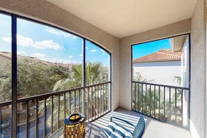 A balcony with a view of a residential area, a striped sofa, and a decorative lamp. - Calm Condo With Pool, hot Tub, Balcony, Cabana, & Kitchen - Snowbird-friendly (Davenport)