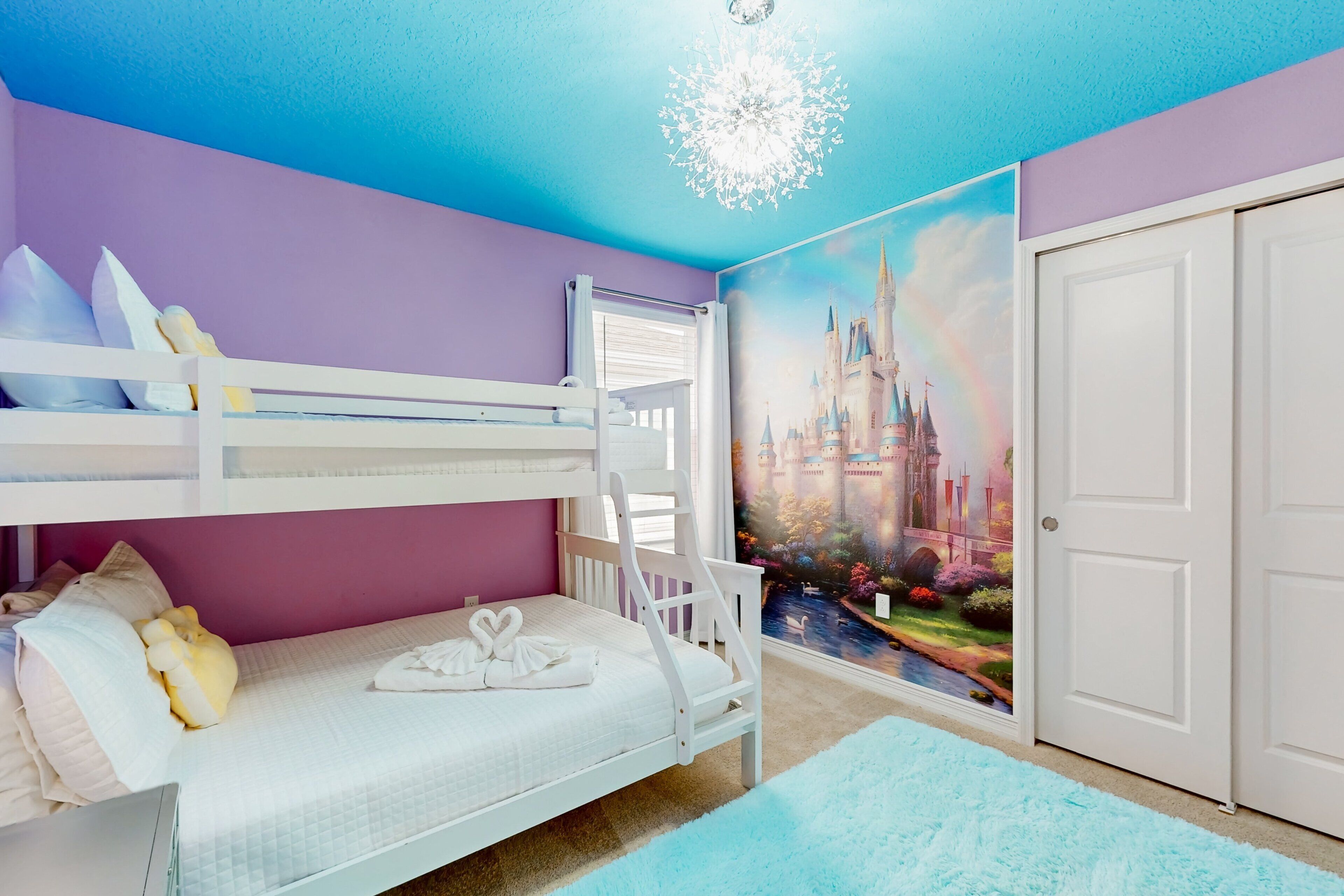 Ein Kinderzimmer mit Etagenbetten, einer Burg-Mural und einer weißen Tür.