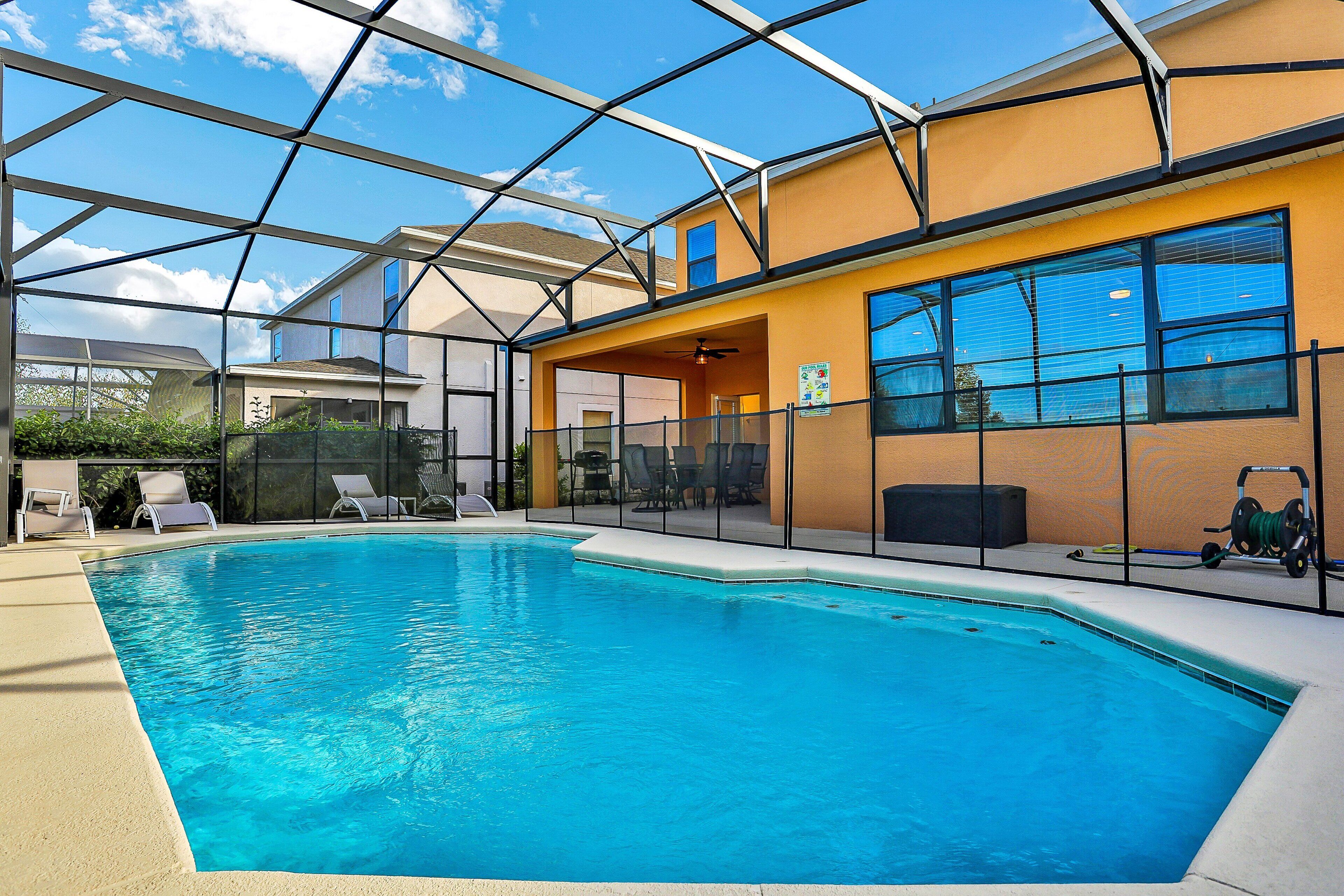 Une piscine intérieure dotée d’un toit en verre, de chaises longues et offrant une vue sur le ciel.