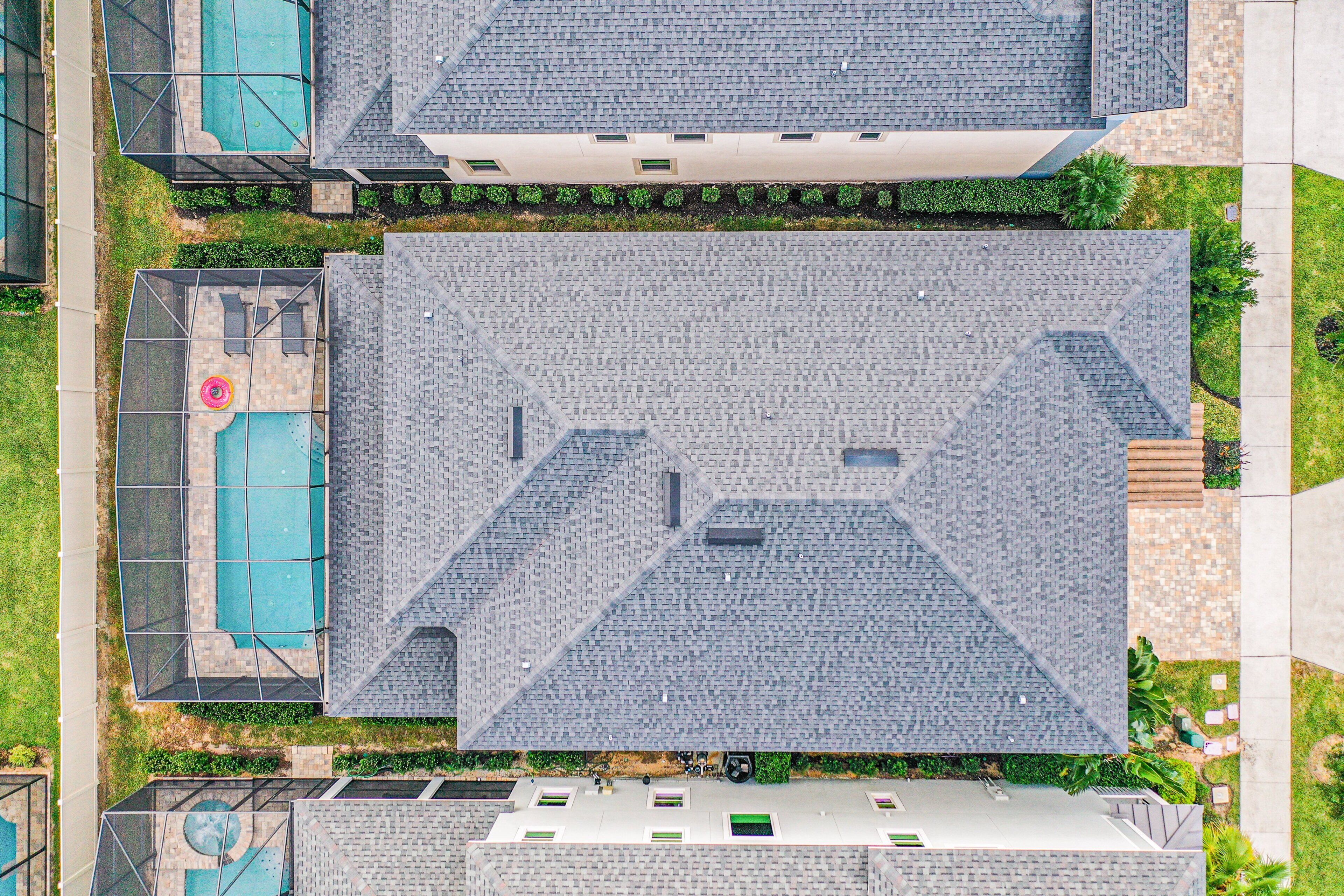 Un tetto con motivo geometrico, una piscina e un giardino curato.