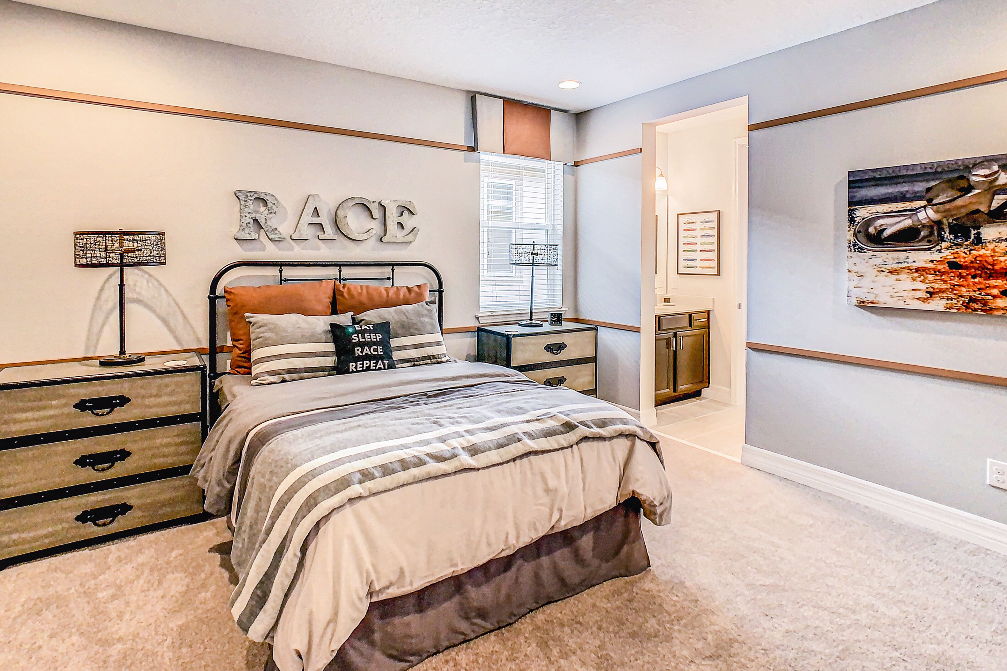 A bedroom with a bed, nightstands, a dresser, and a wall-mounted artwork.
