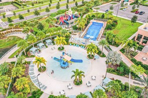 A circular water park with slides and a pool, surrounded by palm trees and outdoor seating. - Resort Home With Private Pool, Patio, Foosball & 2 Living Areas - Near Disney (Kissimmee)