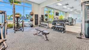A gym with exercise equipment, a bench, and a large mirror. - New Home With Private Pool/spa & Resort Waterpark/arcade Access (Davenport)
