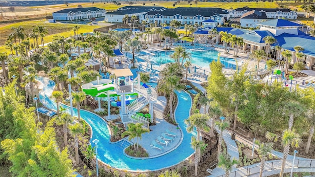 A resort with a large pool area, multiple buildings, and surrounding greenery. - New Home With Private Pool/spa & Resort Waterpark/arcade Access (Davenport)