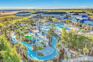 A resort with a large pool area, multiple buildings, and surrounding greenery. - New Home With Private Pool/spa & Resort Waterpark/arcade Access (Davenport)