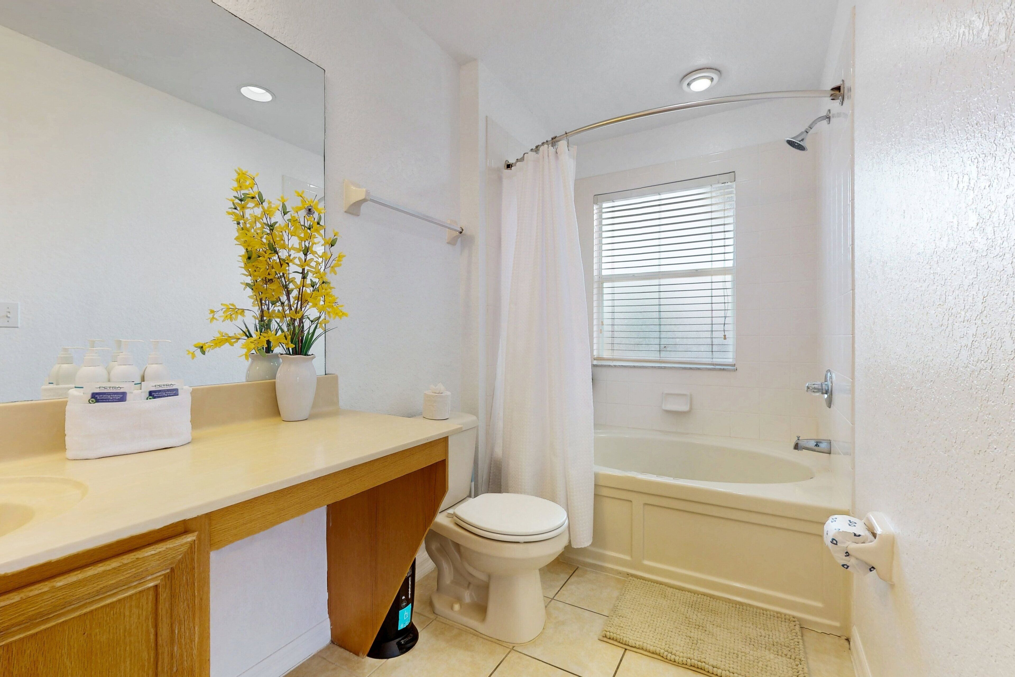 A bathroom with a toilet, sink, mirror, shower, and bathtub.