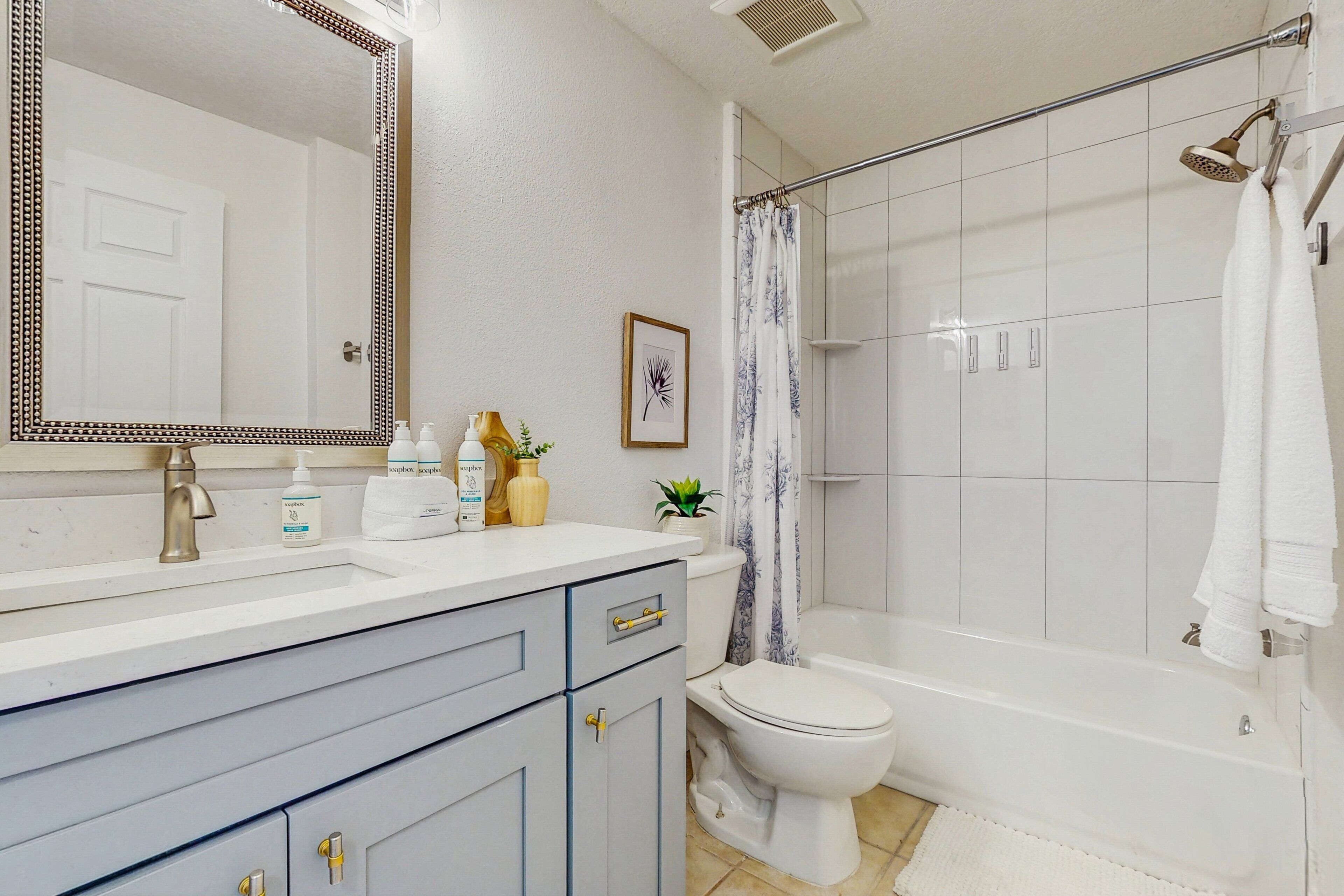 A bathroom with a white sink, a toilet, a bathtub, and a shower curtain.