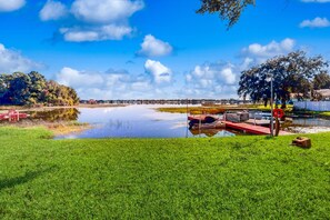 A lakeside park with a dock, grassy areas, and trees. - Lakefront Home With Water Views, Foosball, Screened Porch, & Private W/D (Lake Placid)