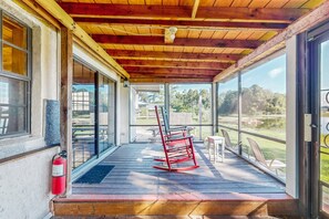 A covered porch with a wooden ceiling, a fire extinguisher, and outdoor seating. - Lakefront Home With Water Views, Foosball, Screened Porch, & Private W/D (Lake Placid)