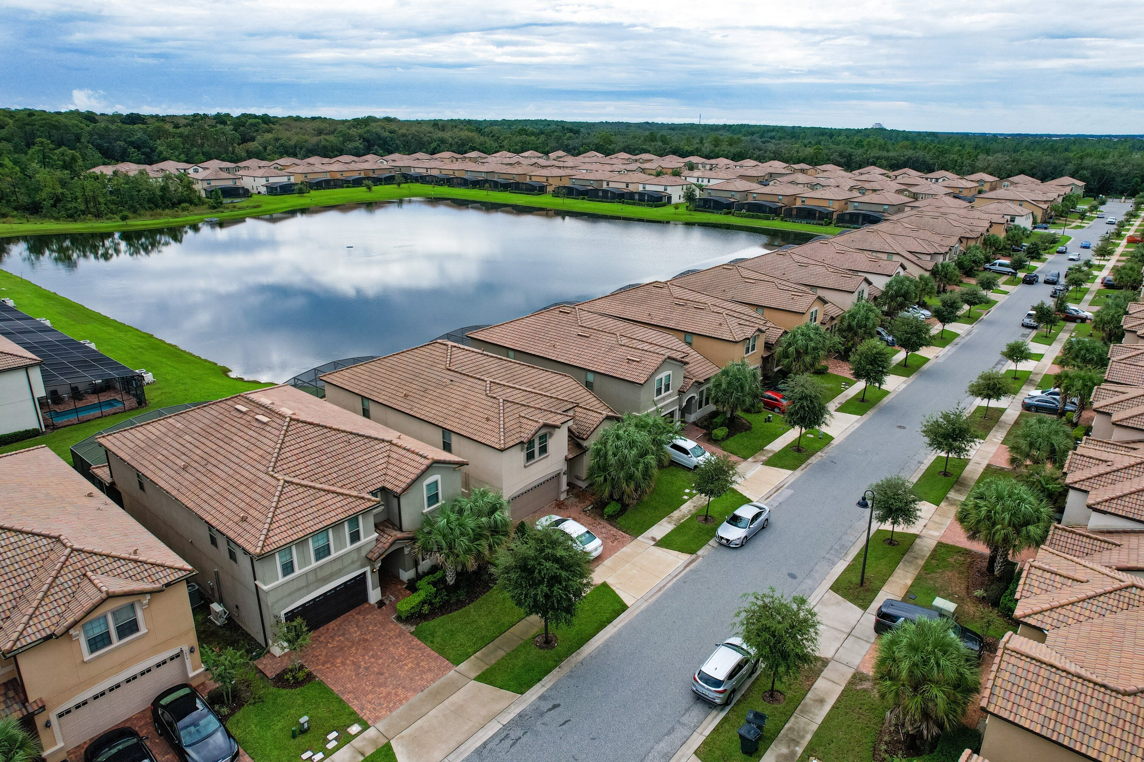 Un barrio residencial con casas, un lago y una carretera.