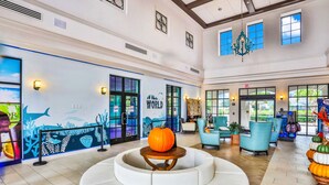 A spacious lobby with a large seating area, a decorative pumpkin centerpiece, and a mural depicting marine life. - Spacious Home w/ Private Pool, Wifi, Central AC, Private Washer/dryer (Kissimmee)