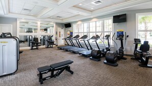 Ein Fitnessstudio mit Laufbändern, Crosstrainern und Gewichten.