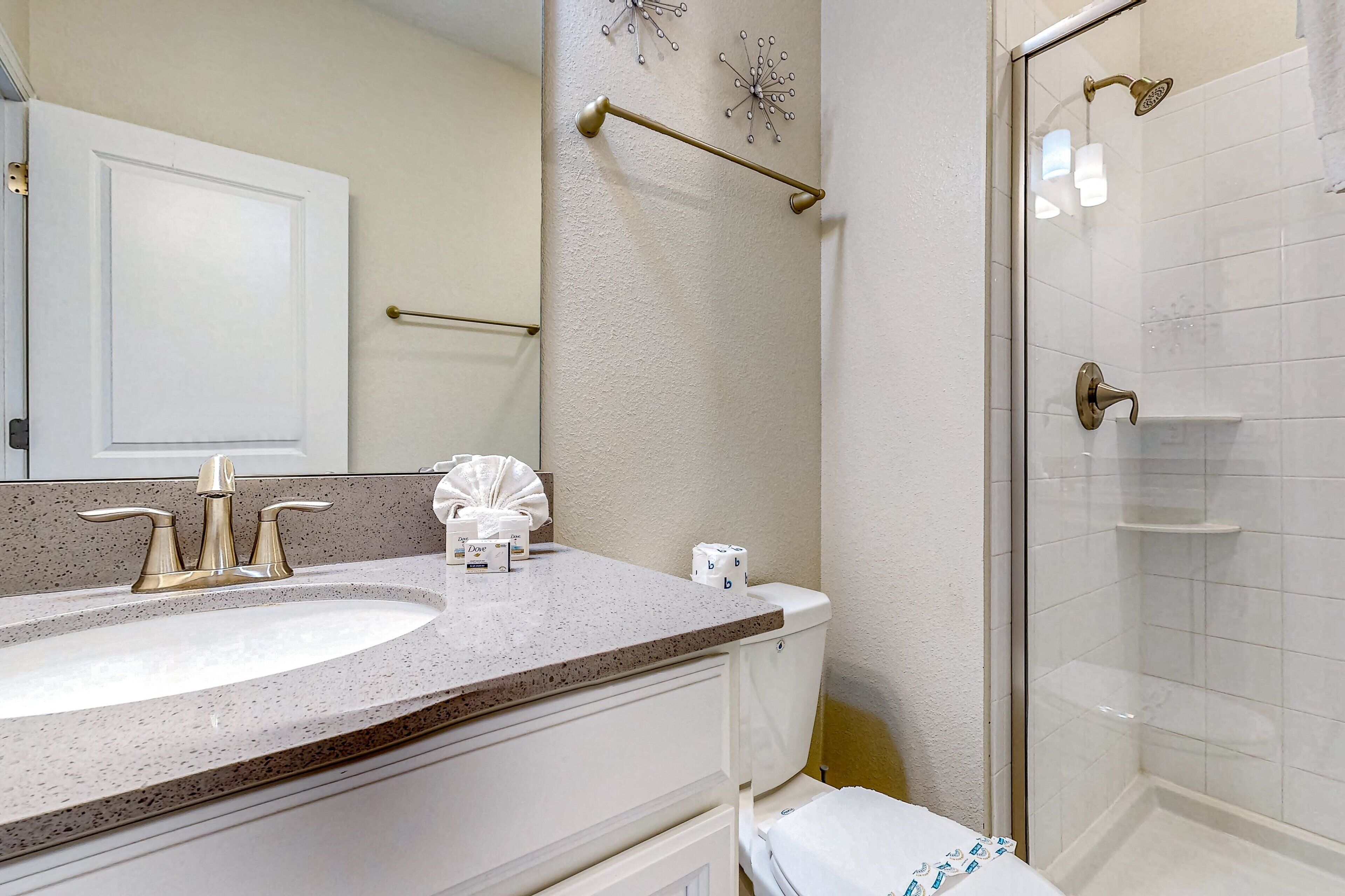 Une salle de bain avec un lavabo, des toilettes et une douche.