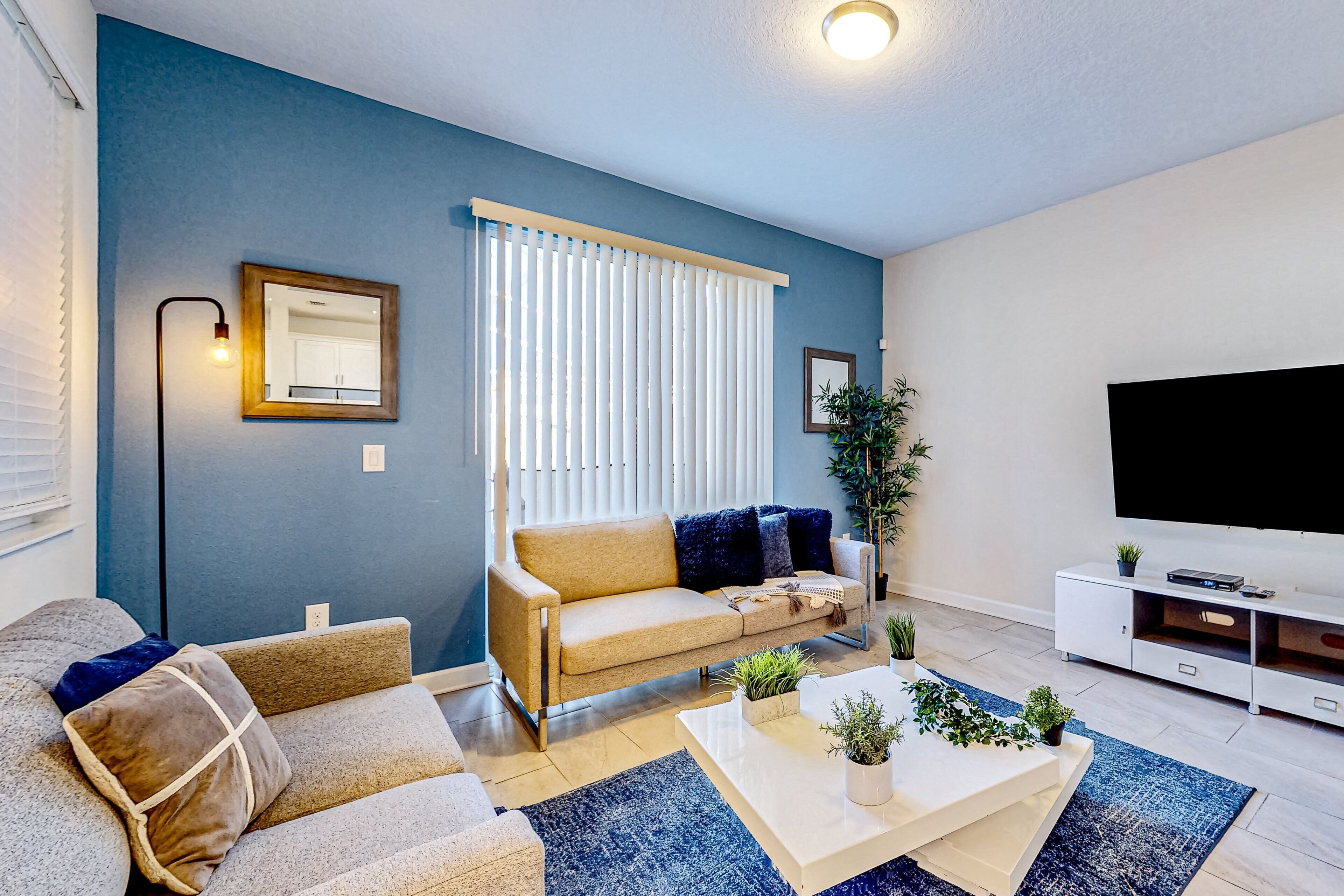 Una sala de estar con sofá, mesa de centro y mueble para televisión.