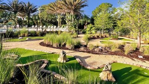 A landscaped garden with pathways, palm trees, and a pool area. - Family-friendly Home With Private Pool, Wifi, Central AC, & Private Washer/dryer (Davenport)