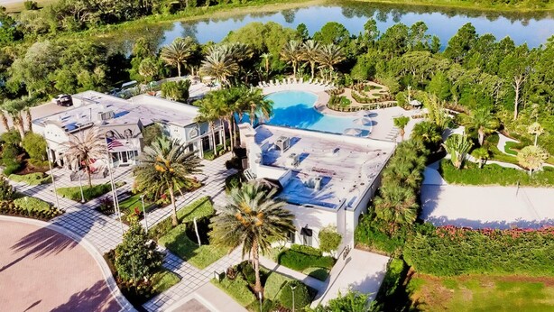 A resort with a swimming pool, palm trees, and a large building with a flat roof. - Family-friendly Home With Private Pool, Wifi, Central AC, & Private Washer/dryer (Davenport)