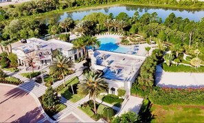 A resort with a swimming pool, palm trees, and a large building with a flat roof. - Family-friendly Home With Private Pool, Wifi, Central AC, & Private Washer/dryer (Davenport)