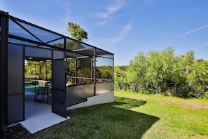 A modern glass-enclosed structure with a pool and outdoor seating. - Stunning House With Lanai, Pool, Ping-pong, Full Kitchen, & Wifi (Davenport)