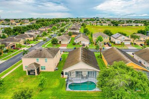 Un quartier résidentiel avec des maisons, une piscine et une route.