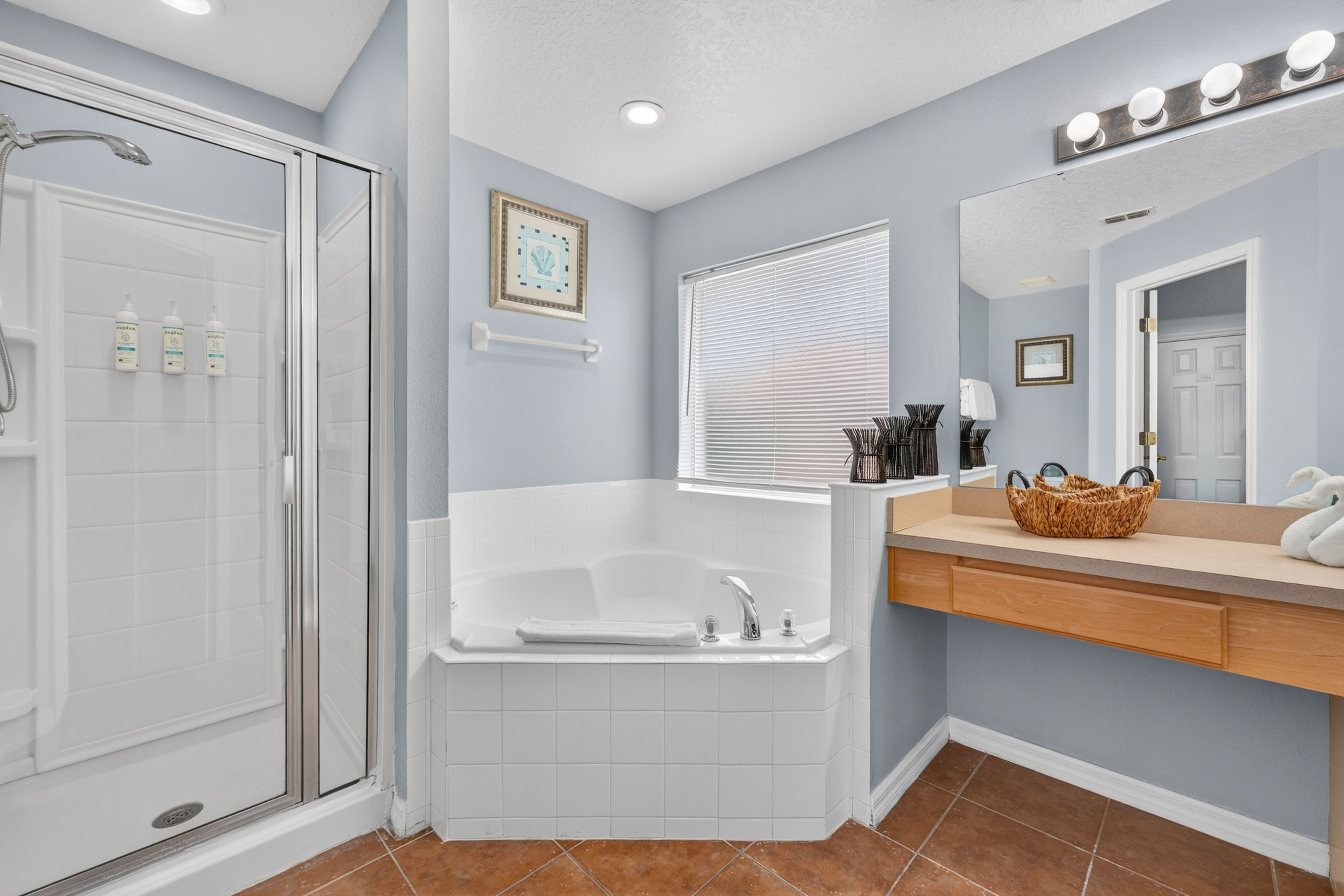 Une salle de bain avec une douche à l’italienne, une baignoire et un meuble-lavabo avec un miroir.