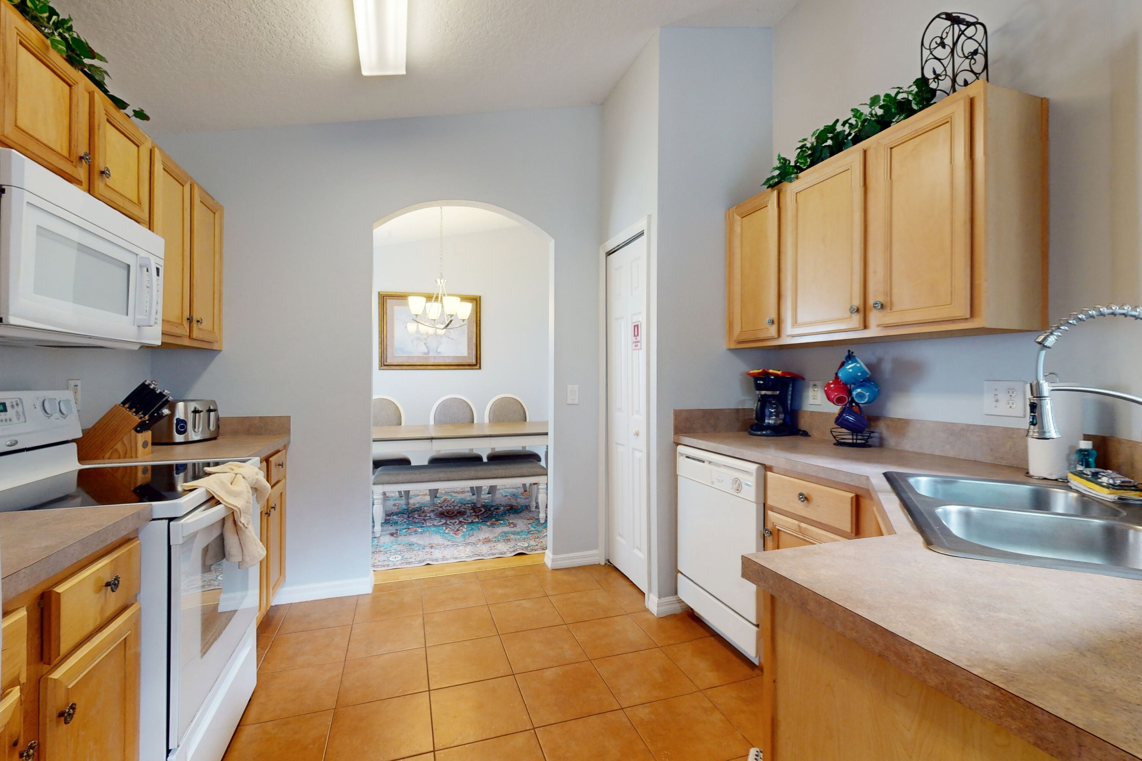 A kitchen with wooden cabinets, a microwave, a stove, and a sink.