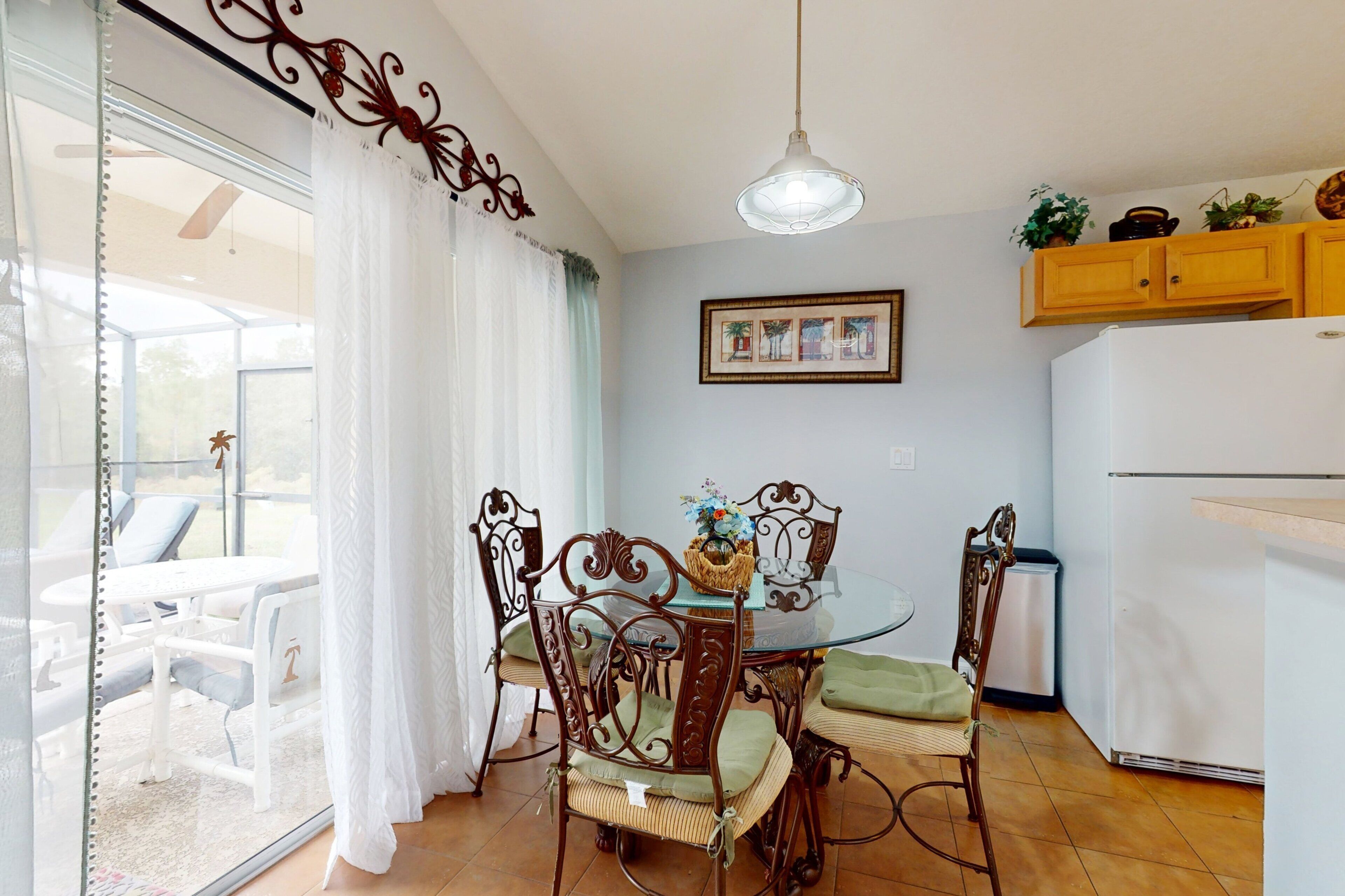 A dining area with a glass table, chairs, and a ceiling light.