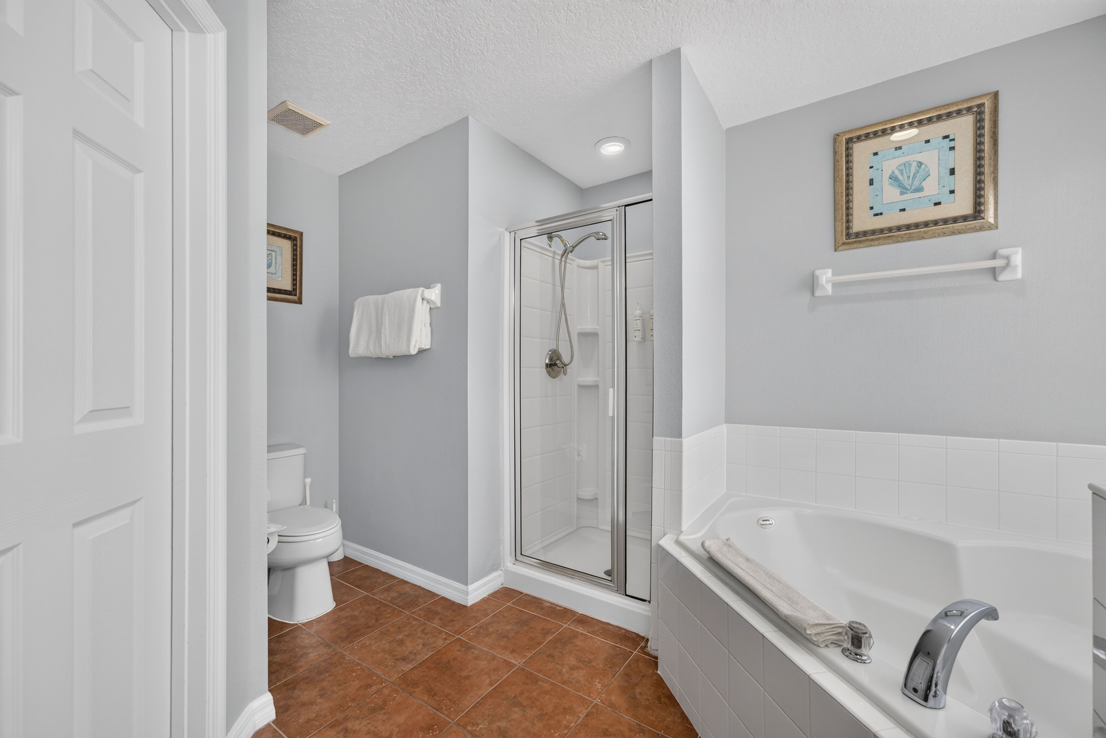 A bathroom with a shower, toilet, and bathtub.