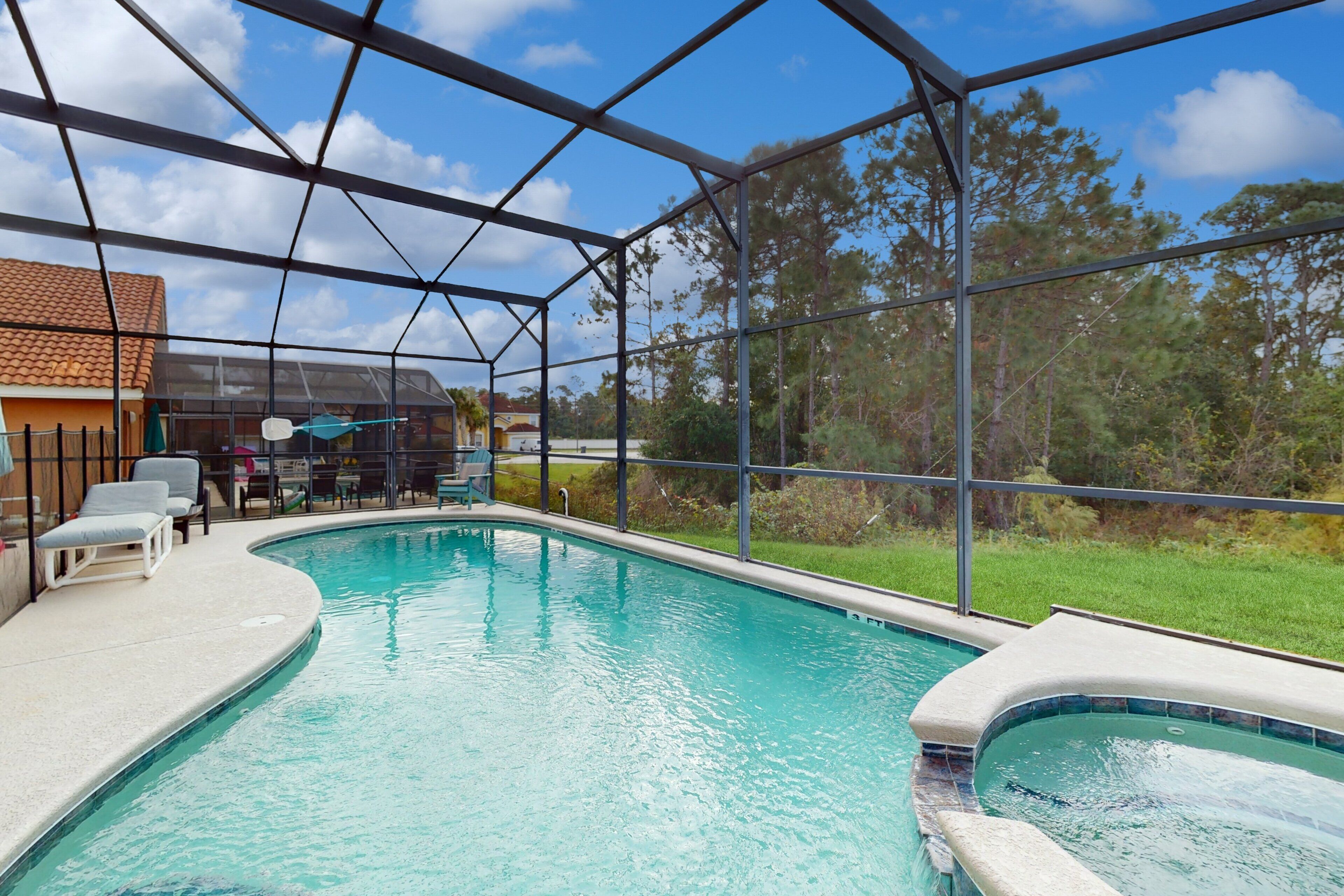 Una piscina interior con paredes de vidrio transparente, un solárium con baldosas y algunas sillas de descanso.
