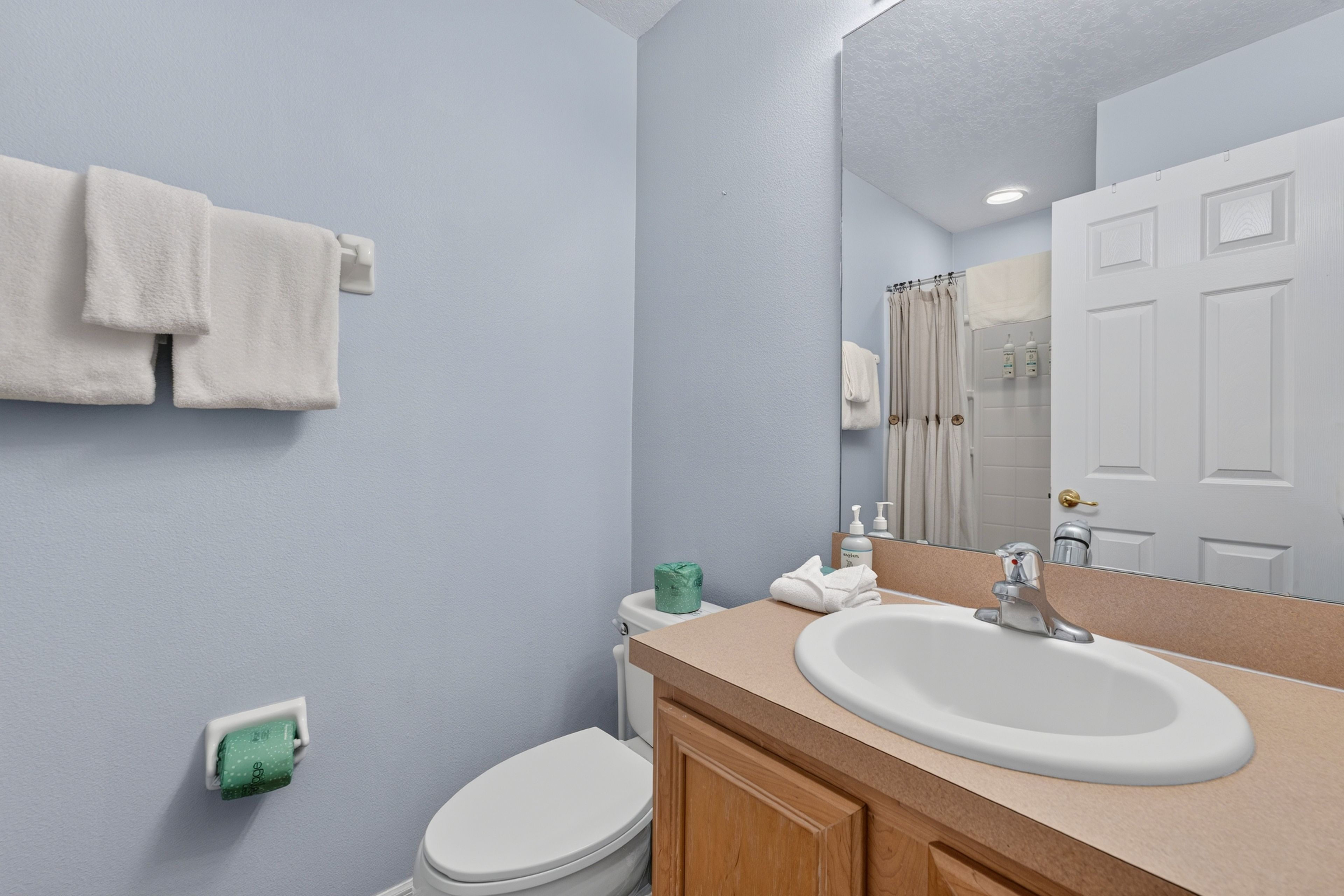 A bathroom with a sink, toilet, and a mirror.