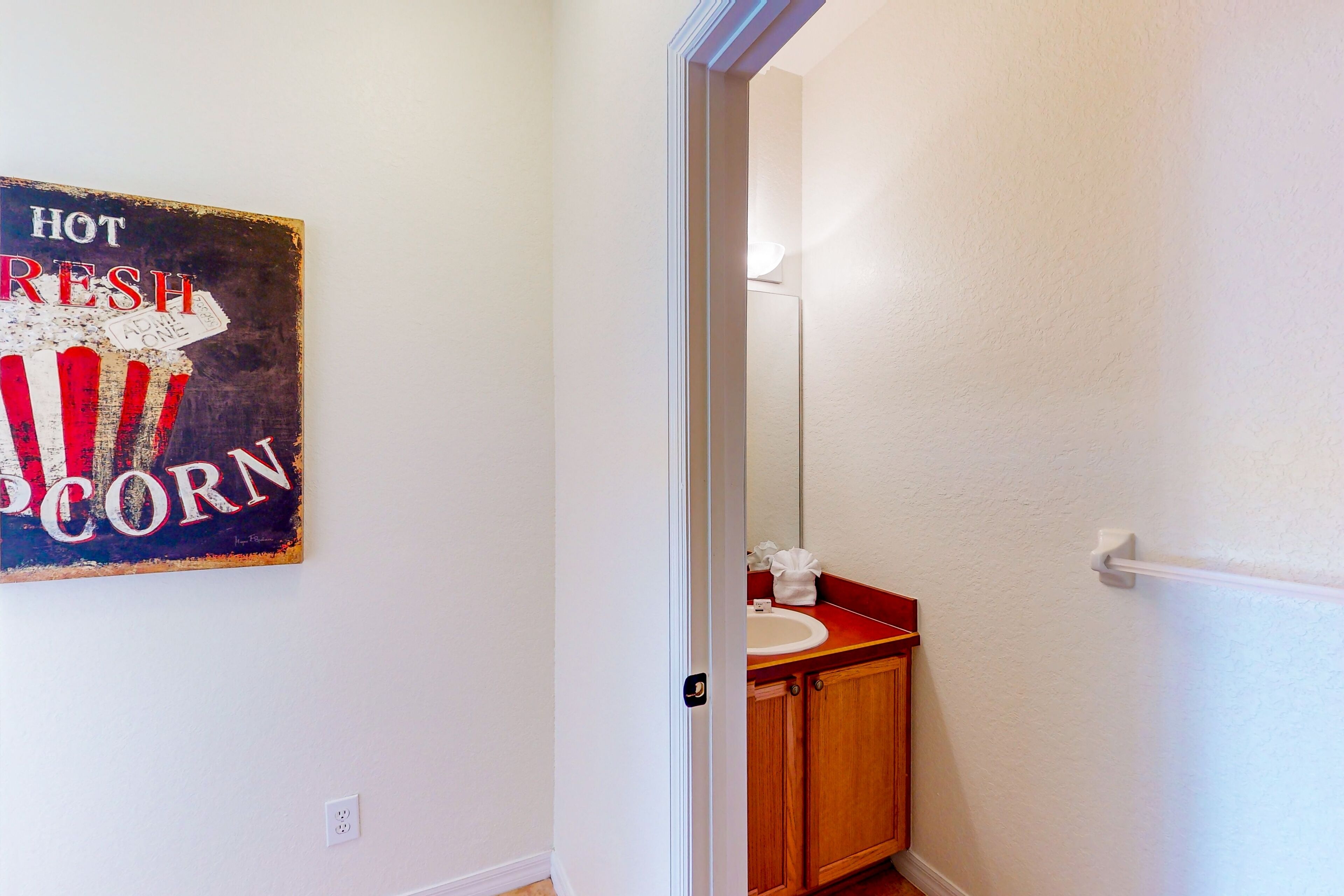 A bathroom with a wooden cabinet, a white sink, and a mirror.