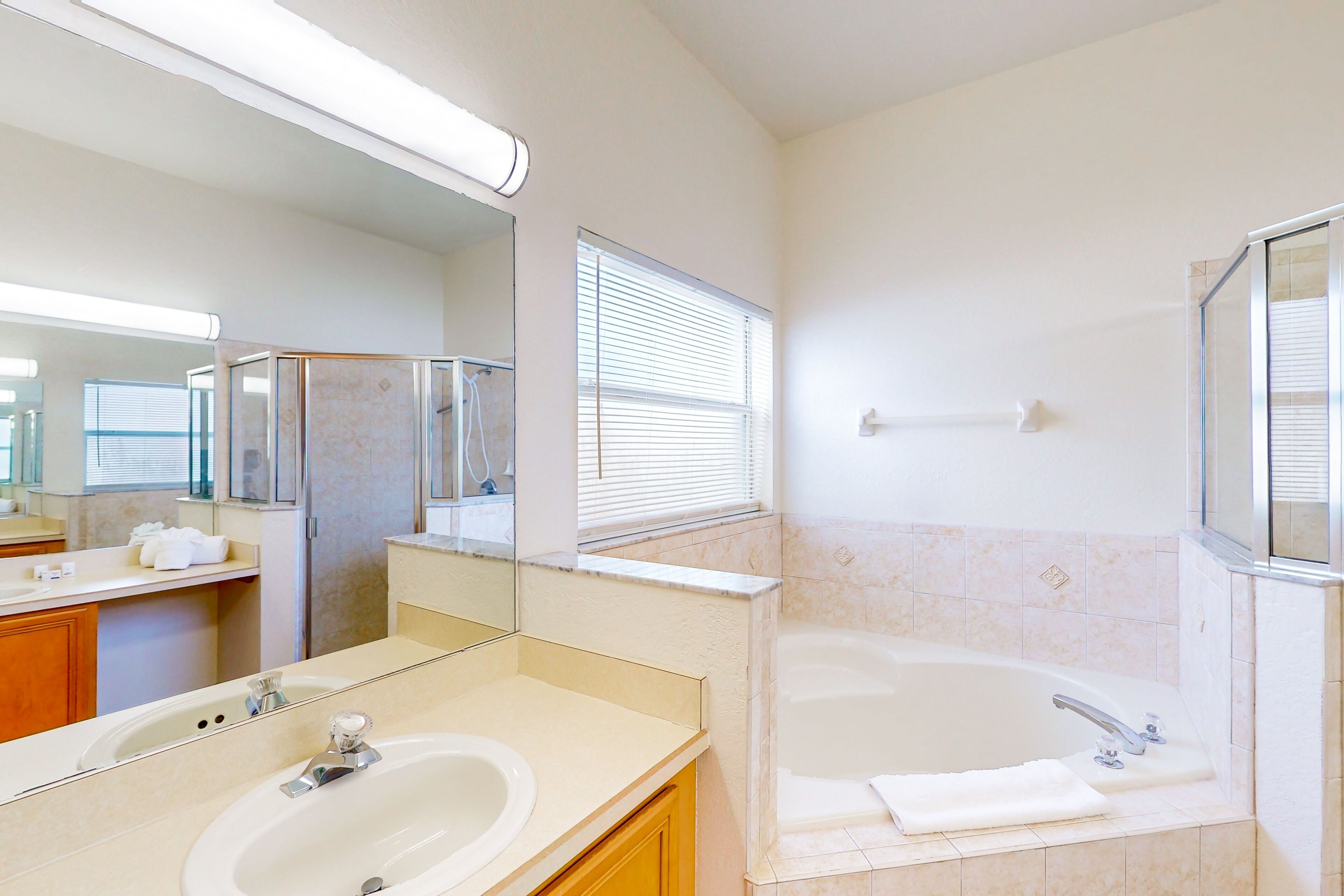 Une salle de bain moderne avec un grand lavabo, une baignoire et un miroir au-dessus du lavabo.