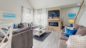A modern living room with a sofa set, a coffee table, and a TV mounted on the wall. - Spacious Condo With Themed Rooms, Foosball Table and Shared Pool (Kissimmee)