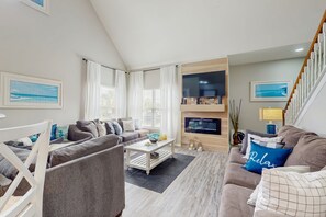 A modern living room with a sofa set, a coffee table, and a TV mounted on the wall. - Spacious Condo With Themed Rooms, Foosball Table and Shared Pool (Kissimmee)