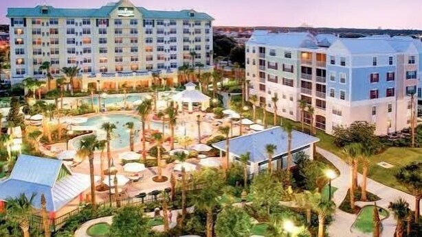 A hotel with multiple buildings, a swimming pool, and landscaped gardens. - Spacious Condo With Themed Rooms, Foosball Table and Shared Pool (Kissimmee)
