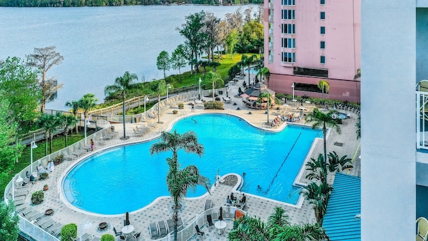 A swimming pool with lounge chairs and a view of a body of water. - Blue Heron Beach I (Orlando)