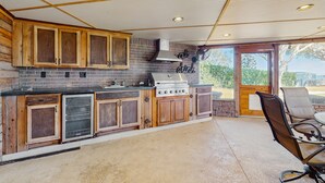 A kitchen with wooden cabinets, a brick backsplash, and a stainless steel stove. - Lakefront 4BR Home With Pool, Outdoor Kitchen & Serene Florida Getaway (Lake Placid)